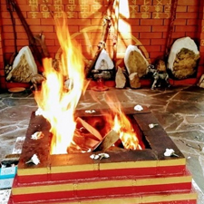 A traditional Hawan setup with sacred fire, offerings, and Vedic symbols.